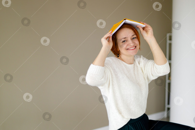 Скачать женщина держит блокнот, заложив руки за голову, и улыбается фотосток Ozero