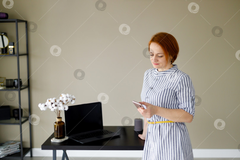 Скачать женщина в полосатом платье на фоне бежевой стены фотосток Ozero