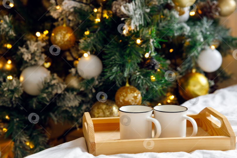 Скачать деревянный поднос и две белые кружки на кровати на белой простыне фотосток Ozero