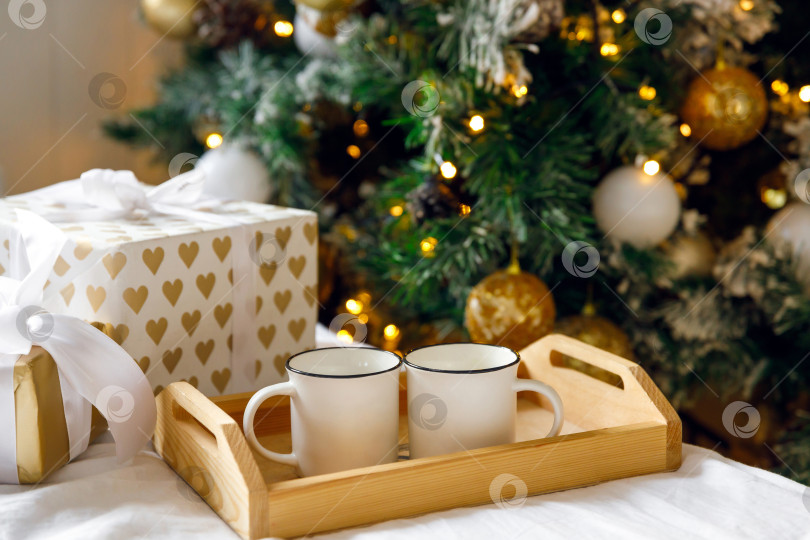 Скачать деревянный поднос и две белые кружки на кровати на белой простыне фотосток Ozero