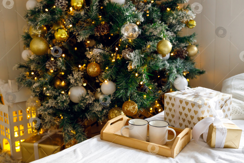 Скачать деревянный поднос и две белые кружки на кровати на белой простыне фотосток Ozero