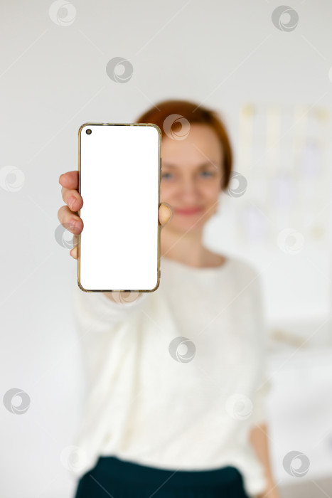 Скачать женщина в белом свитере показывает пустой экран смартфона фотосток Ozero