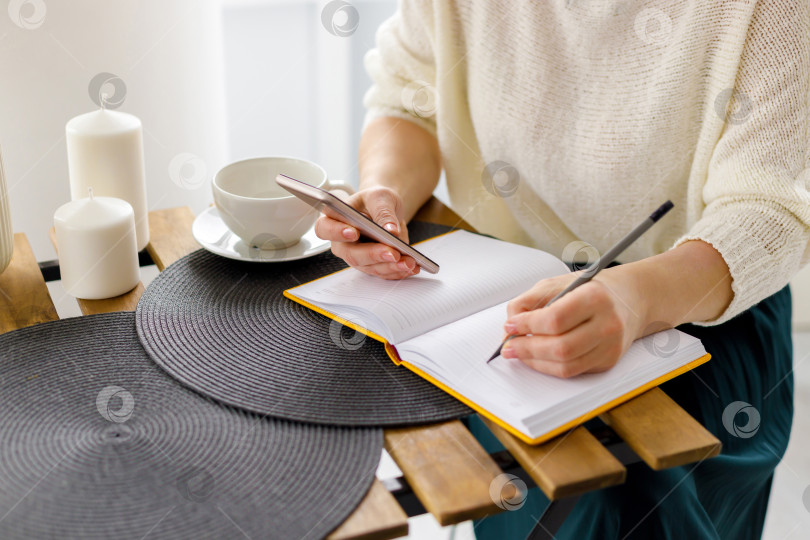 Скачать деловая женщина работает за ноутбуком, держит в руках смартфон фотосток Ozero