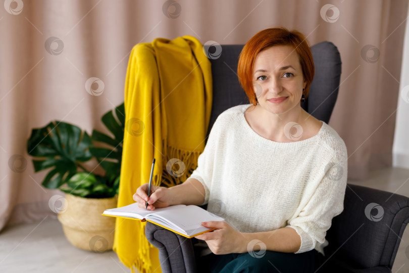 Скачать женщина-блогер делает пометки в желтом блокноте фотосток Ozero