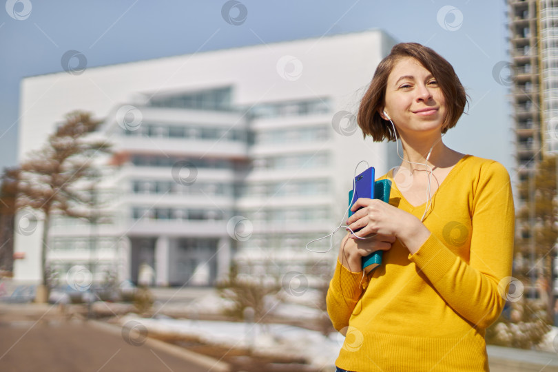 Скачать студентка со смартфоном в руках и наушниках фотосток Ozero