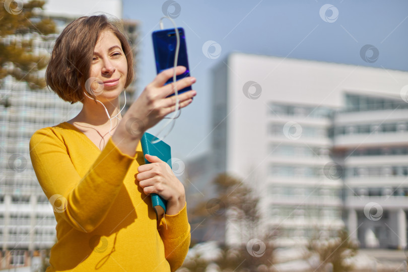 Скачать студентка со смартфоном в руках и наушниках фотосток Ozero