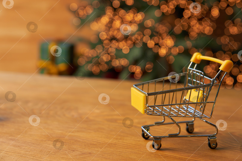 Скачать маленькая модель продуктовой тележки на деревянном фоне. фотосток Ozero