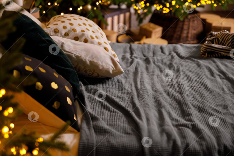Скачать Кровать с подушками и одеялом, рядом с рождественской елкой в спальне фотосток Ozero