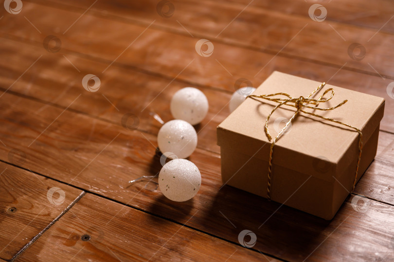 Скачать Рождественский подарок в картонной коробке на деревянном полу фотосток Ozero