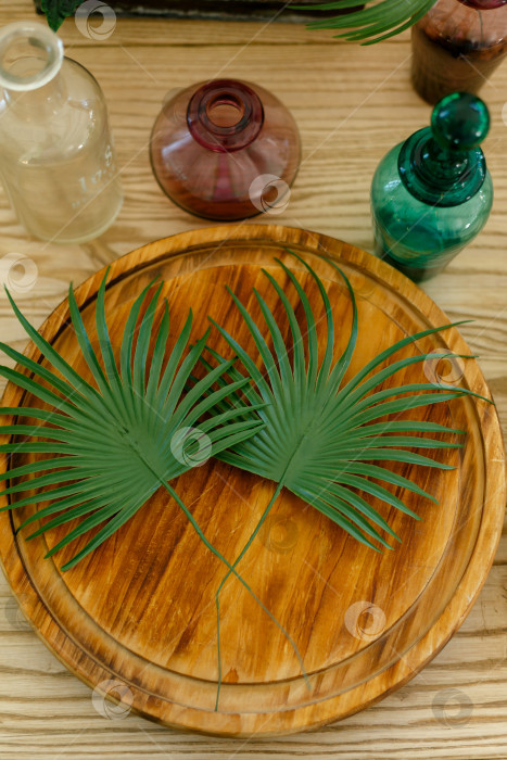 Скачать пальмовые листья лежат на разделочной доске на деревянном столе фотосток Ozero