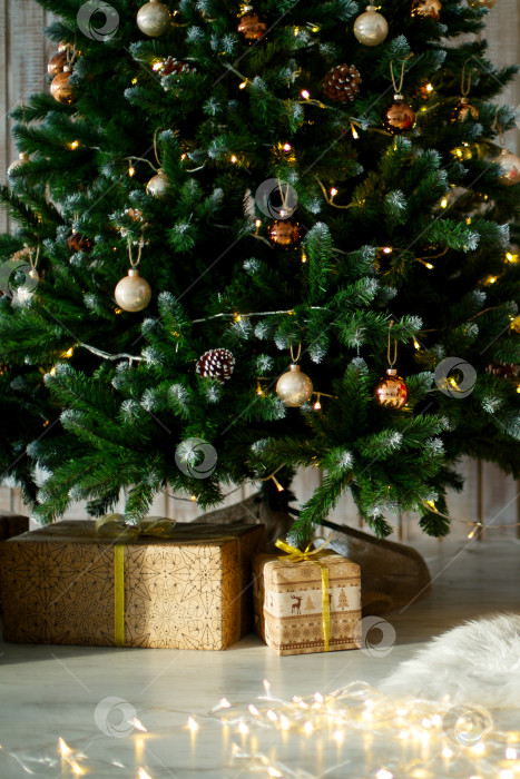 Скачать подарки на деревянном полу, в подарочных коробках под рождественской елкой фотосток Ozero