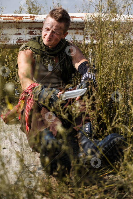 Скачать мужчина-вандал в грязной одежде сидит на заброшенной дороге фотосток Ozero