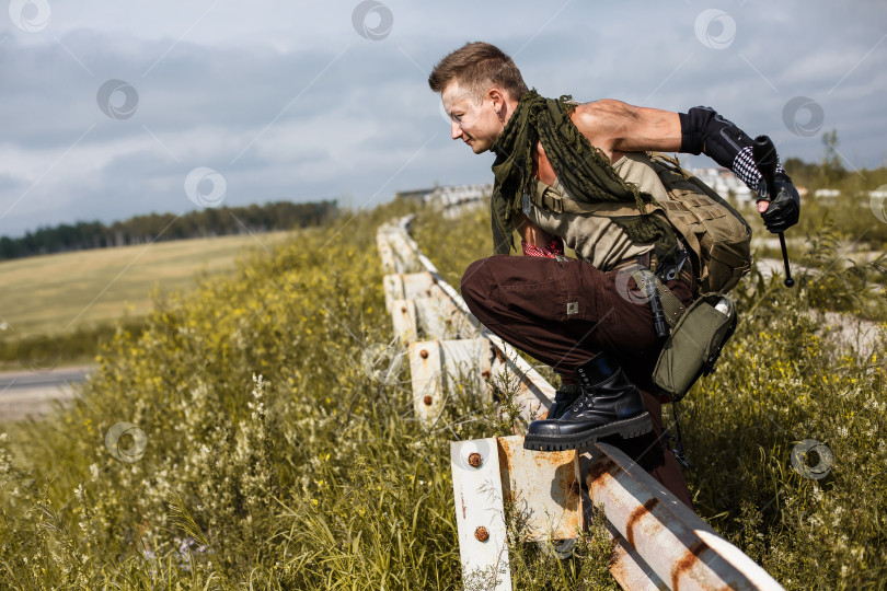 Скачать мужчина-вандал в грязной одежде перепрыгивает через забор фотосток Ozero