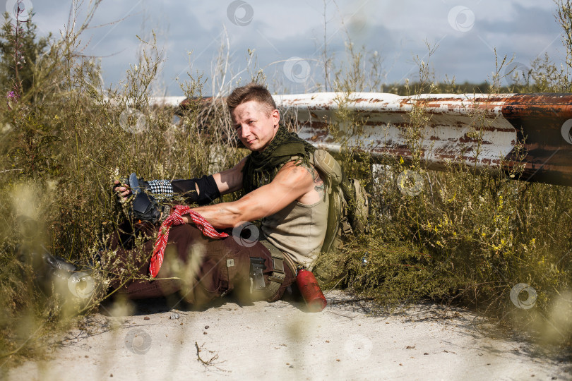 Скачать мужчина-вандал в грязной одежде сидит на заброшенной дороге фотосток Ozero