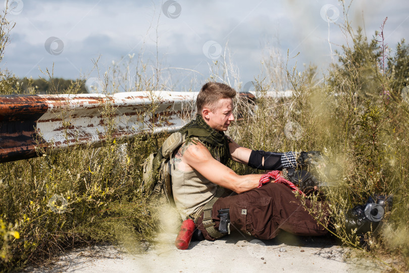 Скачать мужчина-вандал в грязной одежде сидит на заброшенной дороге фотосток Ozero
