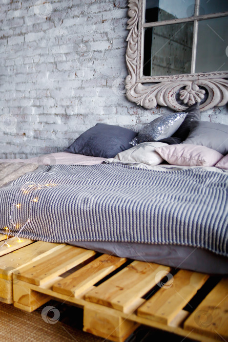 Скачать кровать с серым постельным бельем и подушками на деревянных поддонах фотосток Ozero