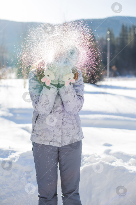 Скачать девушка стоит на улице и дует на снег фотосток Ozero