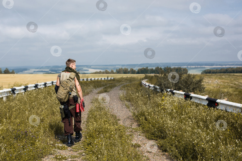 Скачать мужчина в грязной одежде и с рюкзаком фотосток Ozero