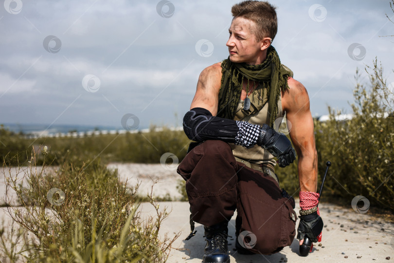 Скачать мужчина-вандал в грязной одежде сидит на заброшенной, заросшей травой дороге фотосток Ozero