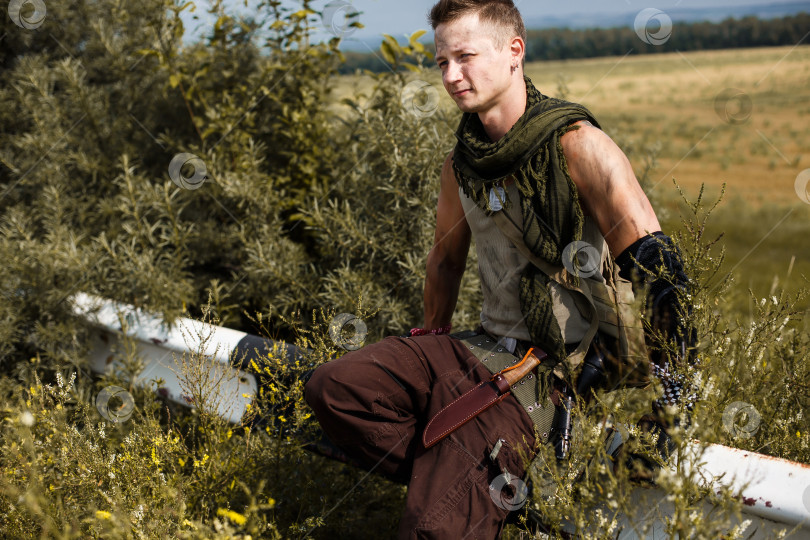 Скачать мужчина-вандал в грязной одежде сидит на заборе фотосток Ozero
