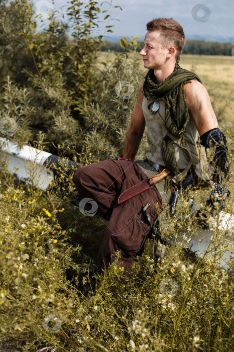 Скачать мужчина-вандал в грязной одежде сидит на заборе фотосток Ozero