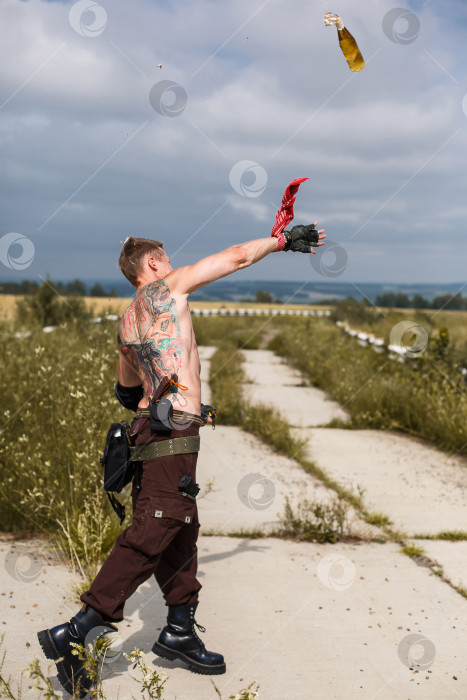 Скачать мужчина-вандал с грязным обнаженным торсом бросает бутылку с зажигательной смесью фотосток Ozero