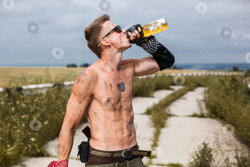 Скачать мужчина-вандал с грязным голым торсом пьет пиво фотосток Ozero
