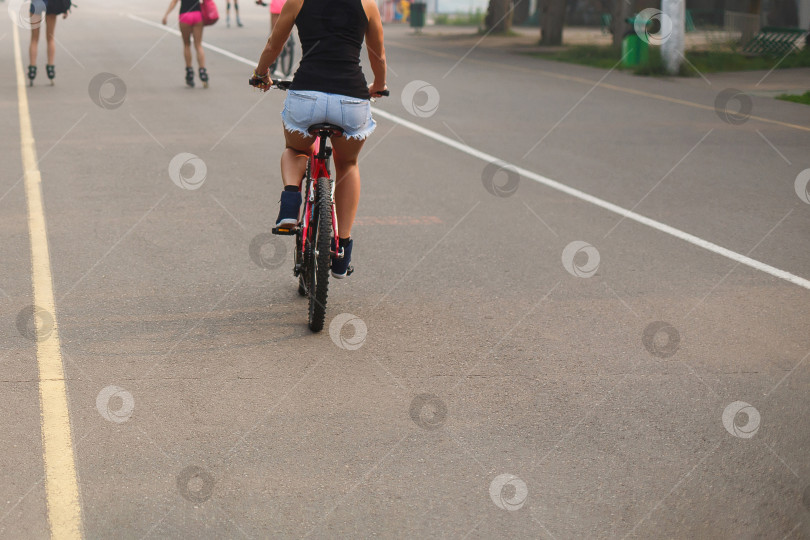 Скачать женщина едет на велосипеде по асфальтированной дороге фотосток Ozero