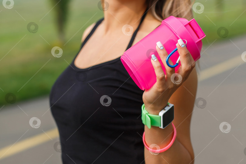 Скачать спортсменка держит в руке шейкер с водой фотосток Ozero