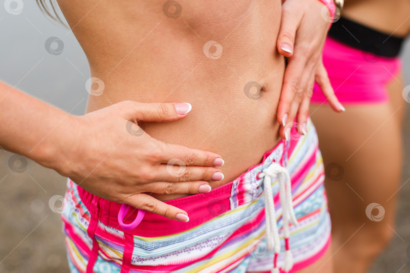 Скачать женщина гладит свой живот руками, крупным планом фотосток Ozero
