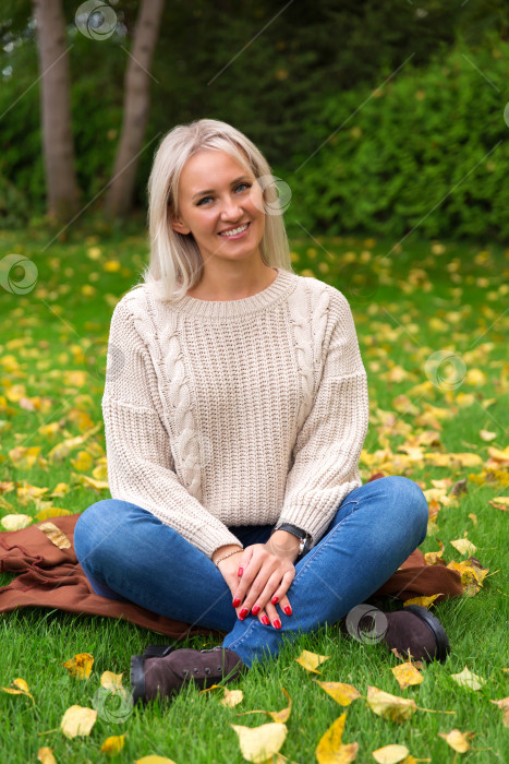 Скачать Женщина сидит, скрестив ноги, на траве фотосток Ozero