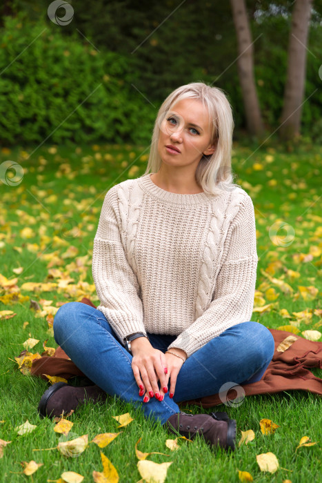 Скачать Женщина сидит, скрестив ноги, на траве фотосток Ozero