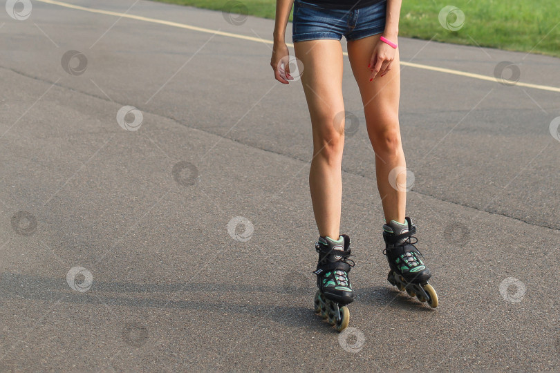 Скачать ноги женщины катаются на роликовых коньках по асфальтированной дороге фотосток Ozero