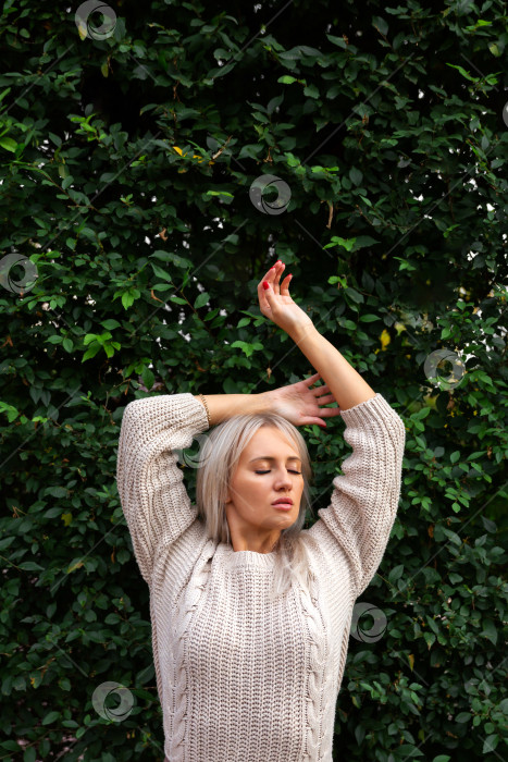 Скачать женщина стоит на фоне стены из листьев фотосток Ozero