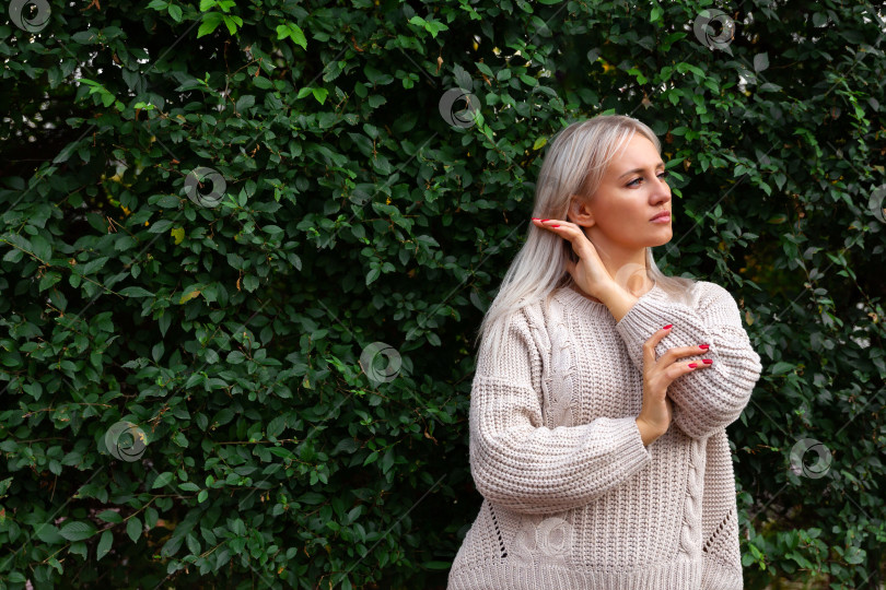 Скачать женщина, стоящая на фоне стены из листьев фотосток Ozero