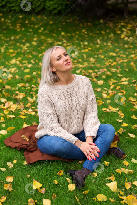 Скачать Женщина сидит, скрестив ноги, на траве фотосток Ozero