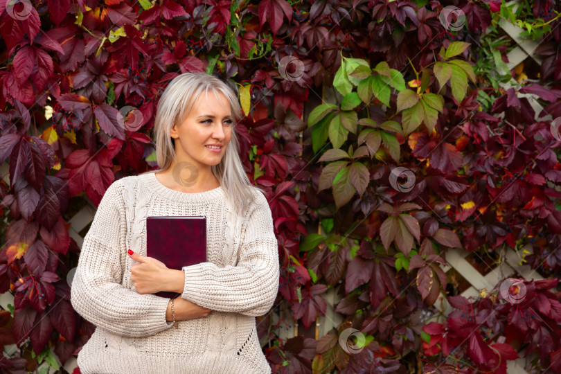 Скачать женщина в свитере стоит с книгой в руках фотосток Ozero