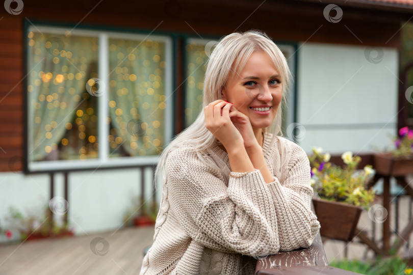 Скачать женщина в свитере улыбается и смотрит в камеру фотосток Ozero