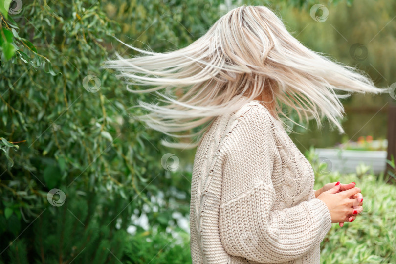 Скачать ветер развевает длинные волосы блондинки в свитере фотосток Ozero