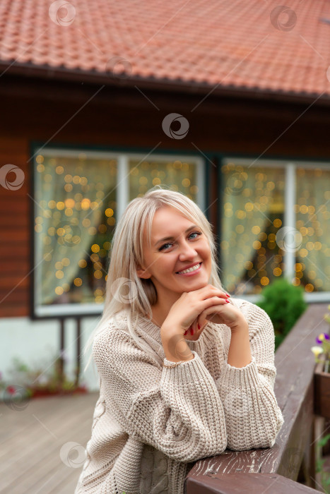 Скачать женщина в свитере улыбается и смотрит в камеру фотосток Ozero
