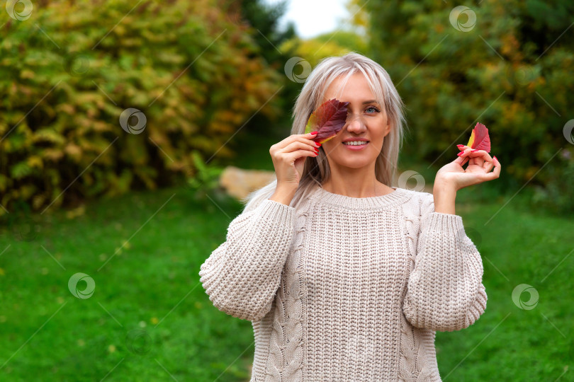 Скачать женщина в свитере держит в руке листок и закрывает глаза фотосток Ozero