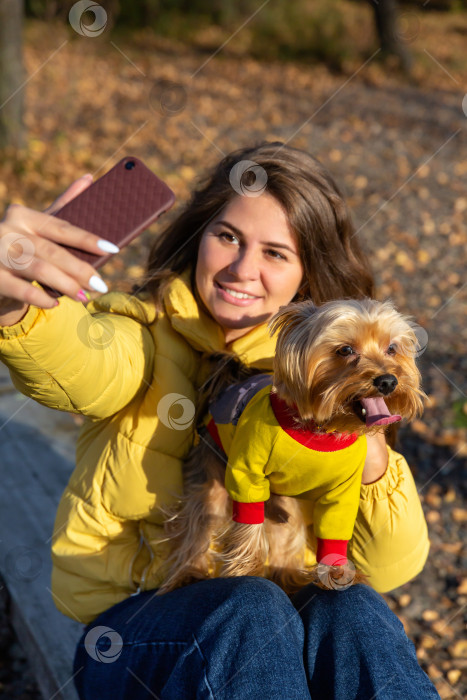 Скачать женщина делает селфи на смартфон со своей маленькой собачкой фотосток Ozero