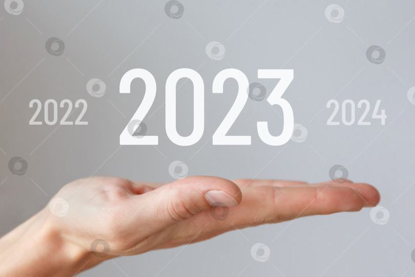 Скачать в руке виртуальные цифры нового 2023 года фотосток Ozero