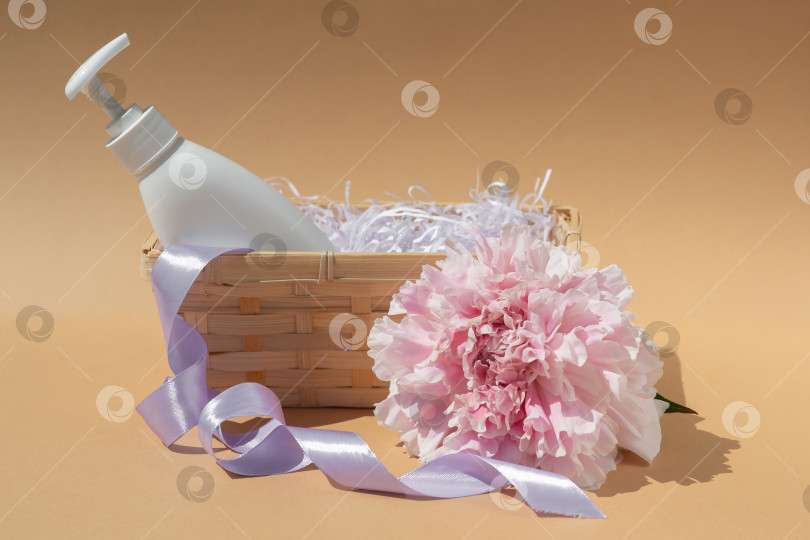 Скачать Белый флакон в плетеной корзинке. Крупный бутон розового пиона. Косметика и парфюмерия. Уход за телом и кожей. Концепция спа-салона фотосток Ozero