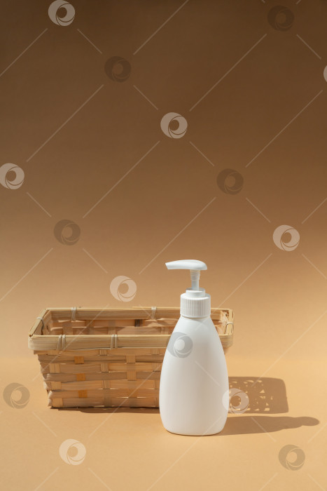 Скачать плетеная корзина и белый флакон-дозатор для спа-косметики на бежевом фоне фотосток Ozero