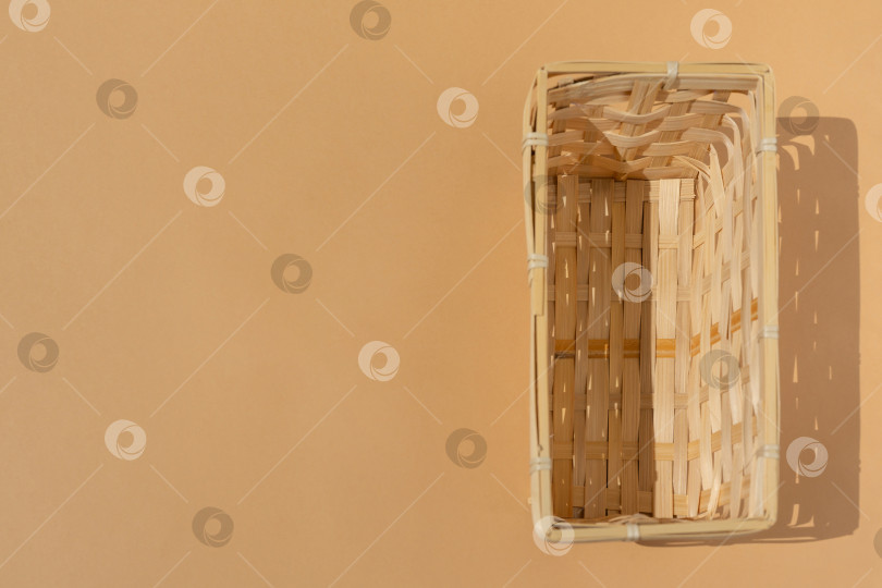 Скачать пустая плетеная корзина для вашего товара на бежевом или коричневом фоне. Макет. Плоская выкладка. Изображение сверху. Вид сверху фотосток Ozero