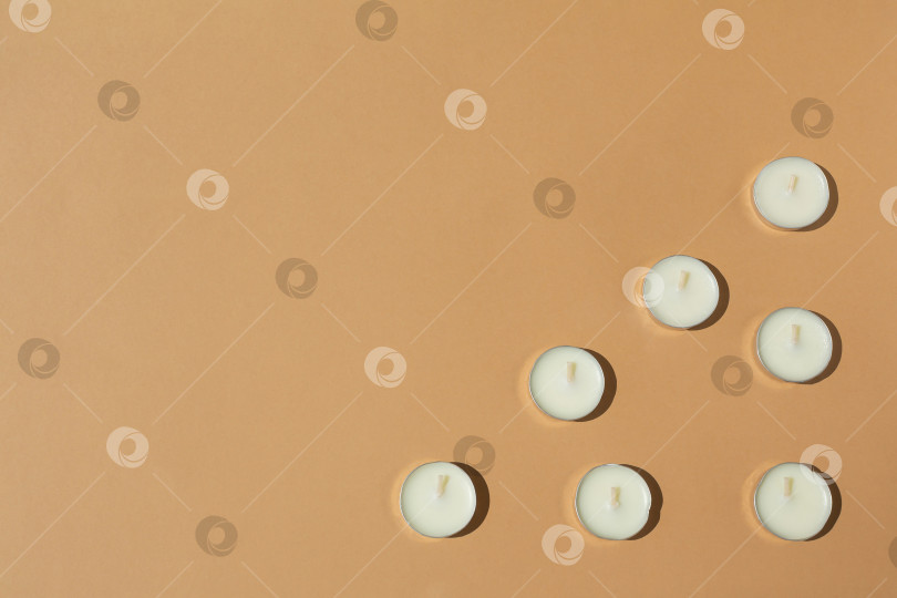 Скачать белые свечи на бежевом фоне. Контрастное освещение. Ровная поверхность фотосток Ozero