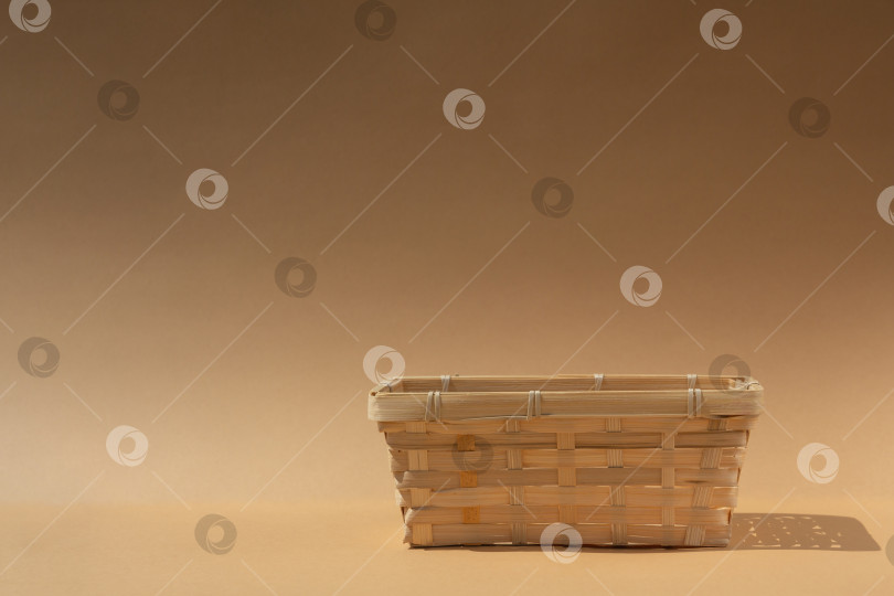 Скачать пустая плетеная корзина для вашего товара на бежевом фоне. Макет фотосток Ozero