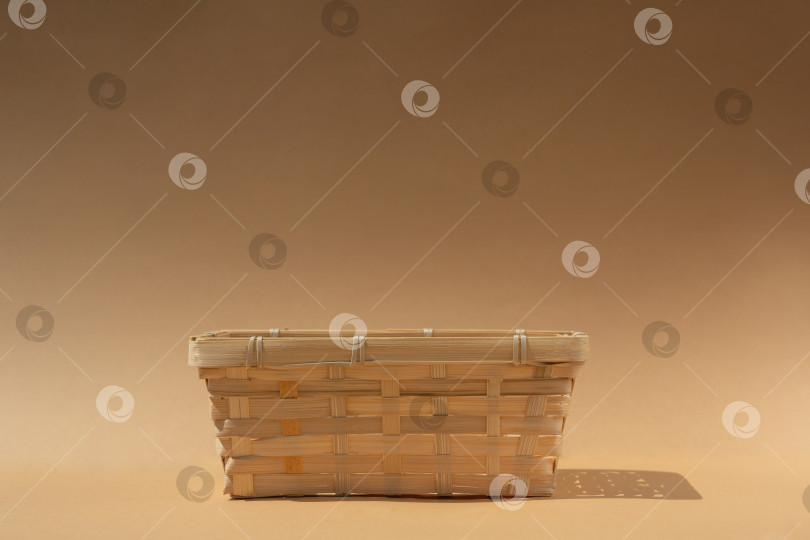 Скачать пустая плетеная корзина для вашего товара на бежевом фоне фотосток Ozero