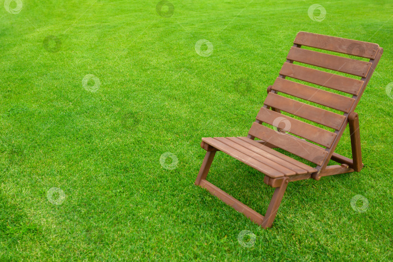 Скачать Реклама для отдыха и туризма. Поставьте пустой коричневый деревянный шезлонг на зеленую траву свежего газона. фотосток Ozero